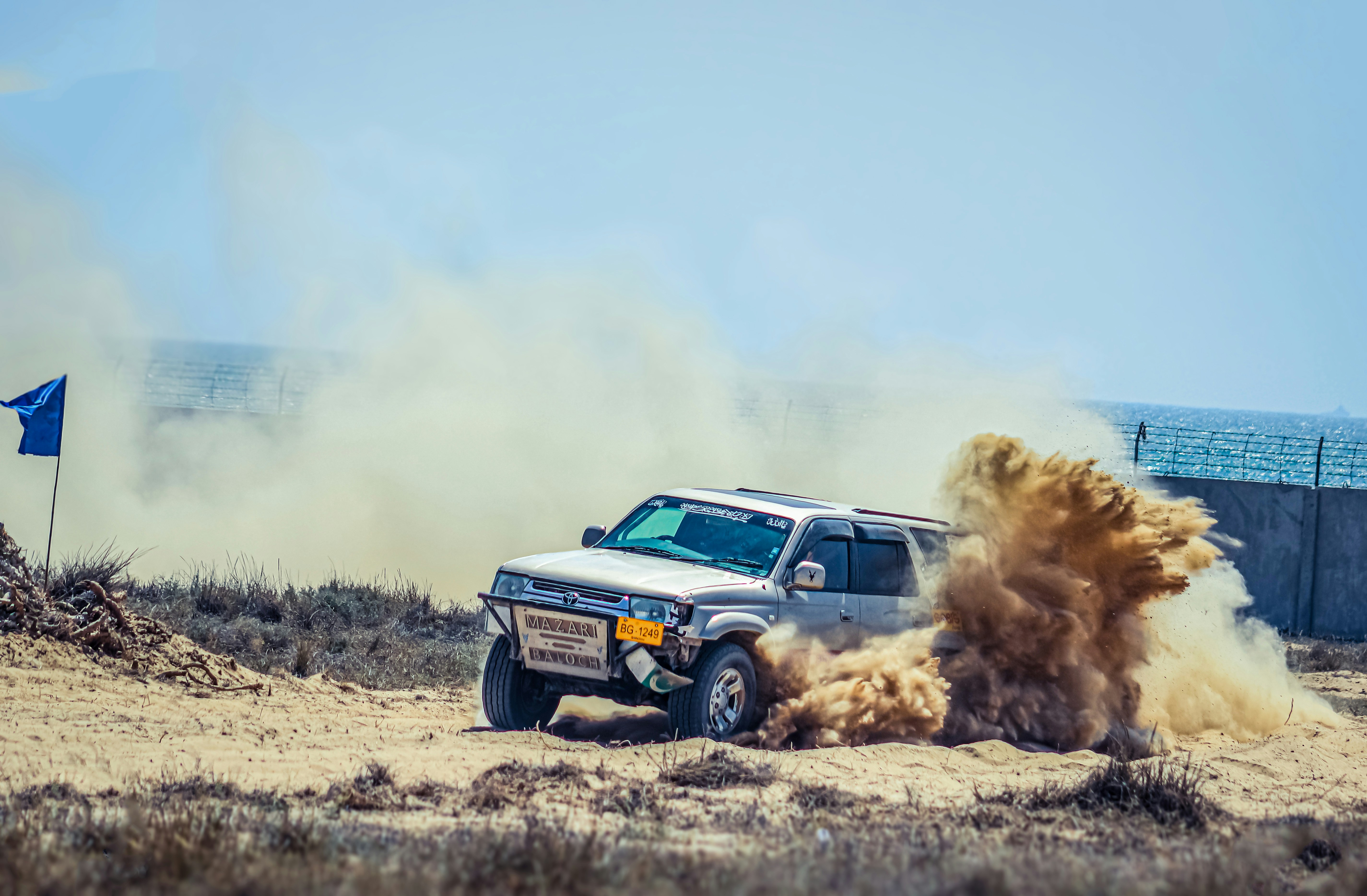 A truck kicking up dirt on a dirt road