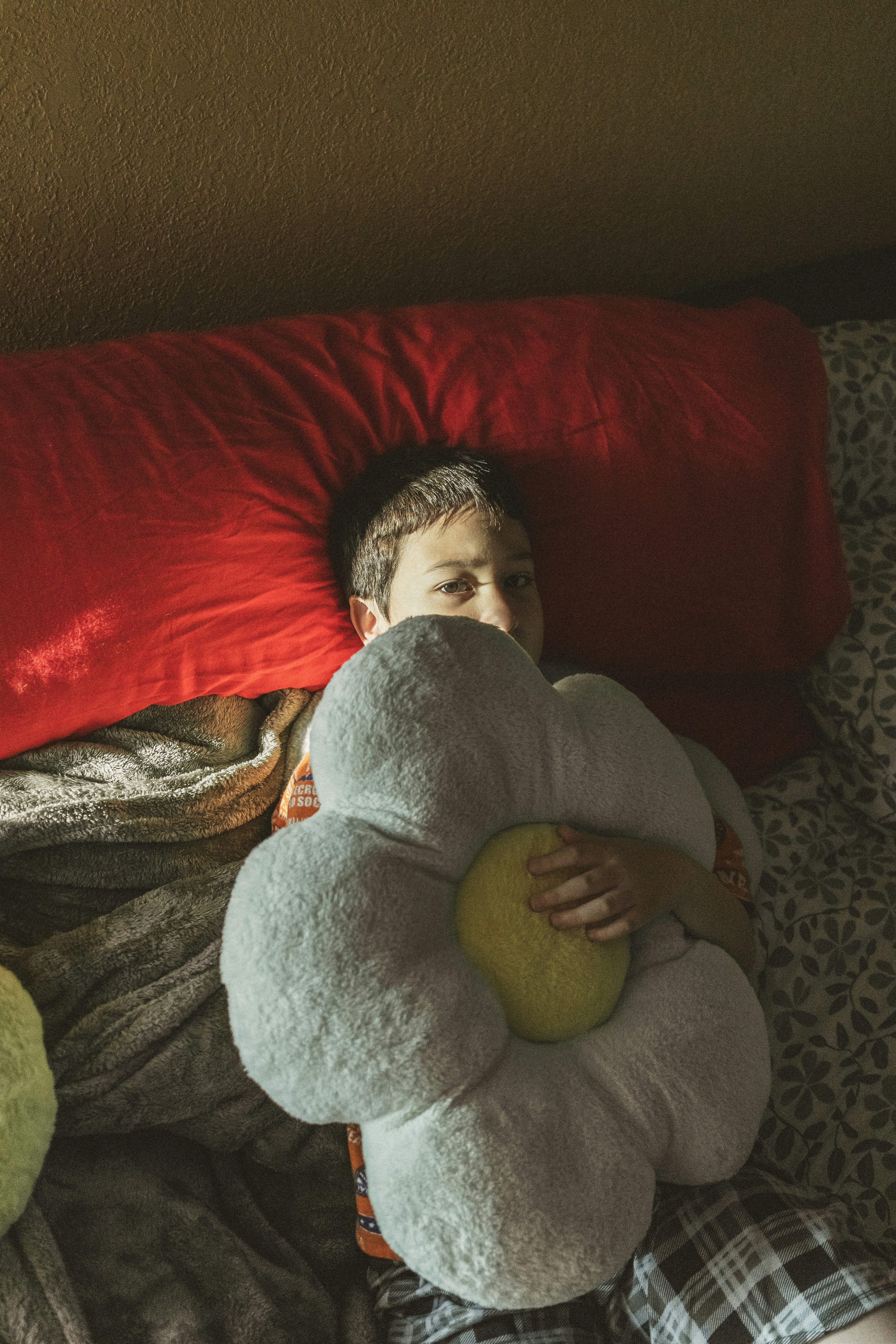 A person laying on a bed with pillows and a pillow