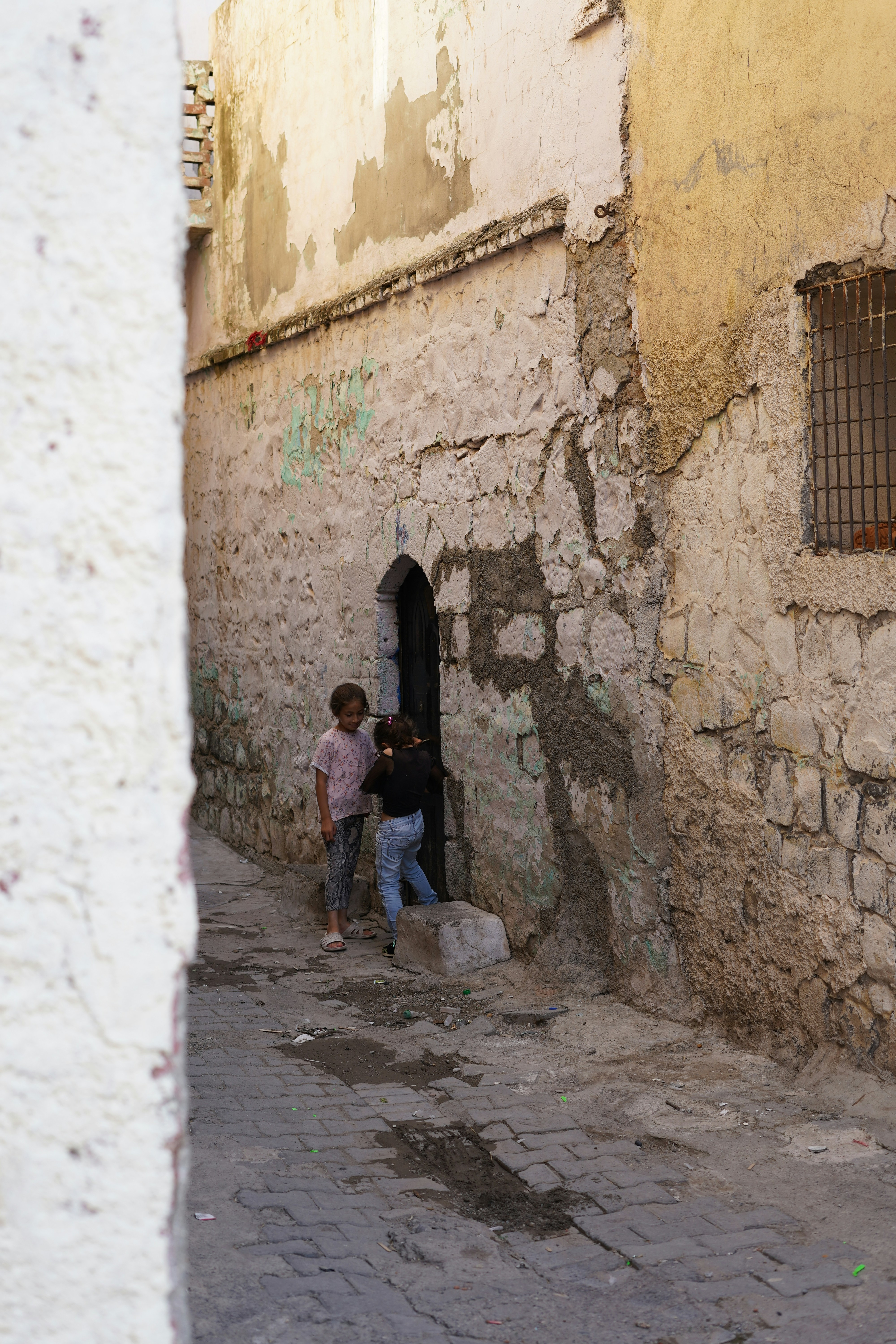 A couple of kids standing next to a building