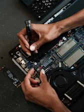 A person working on a laptop with a pen