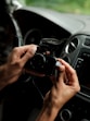 A person holding a camera in a car