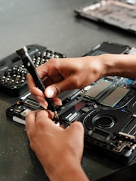 A person is working on a piece of electronics