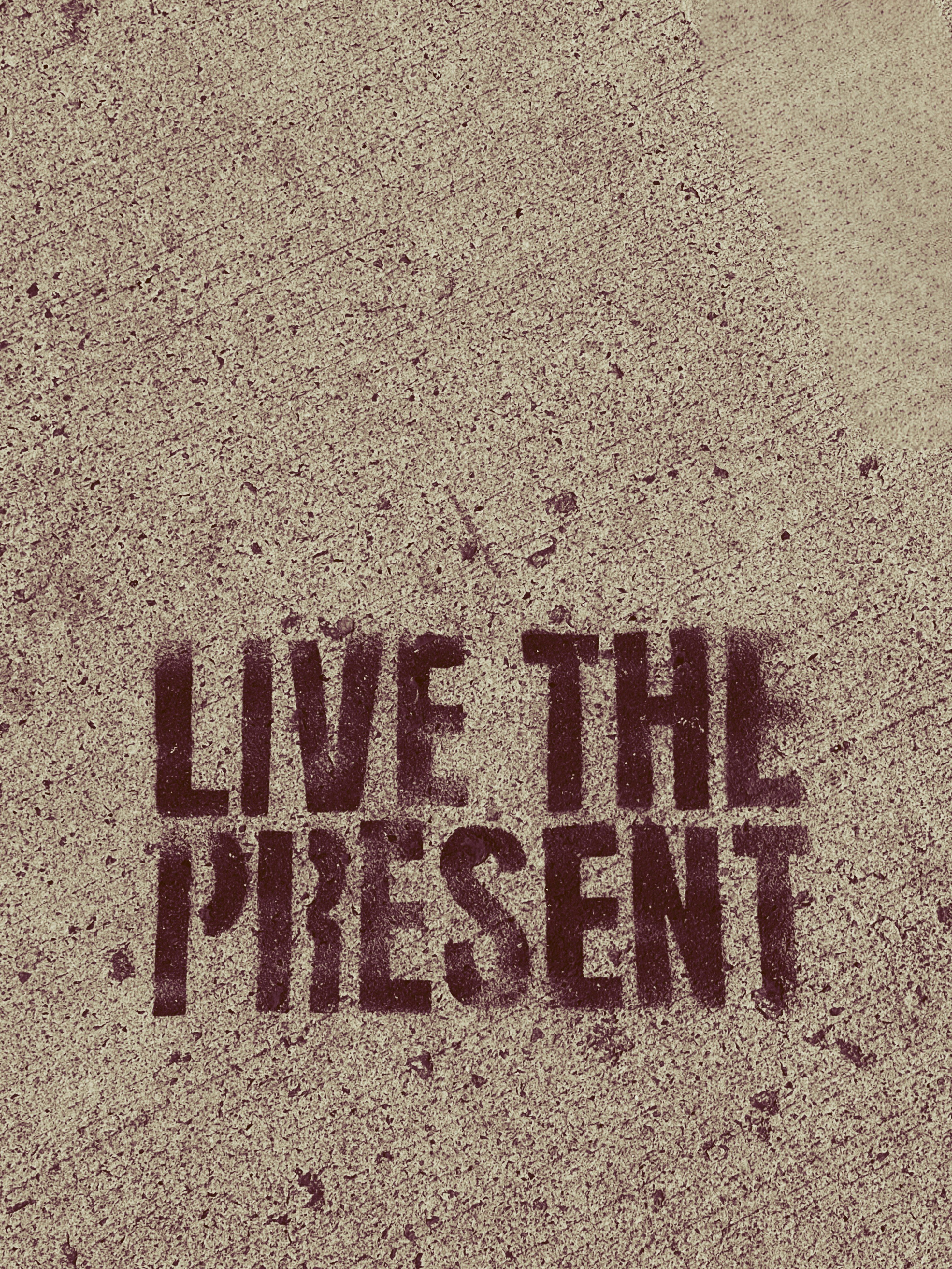 The words live the present written on the sidewalk