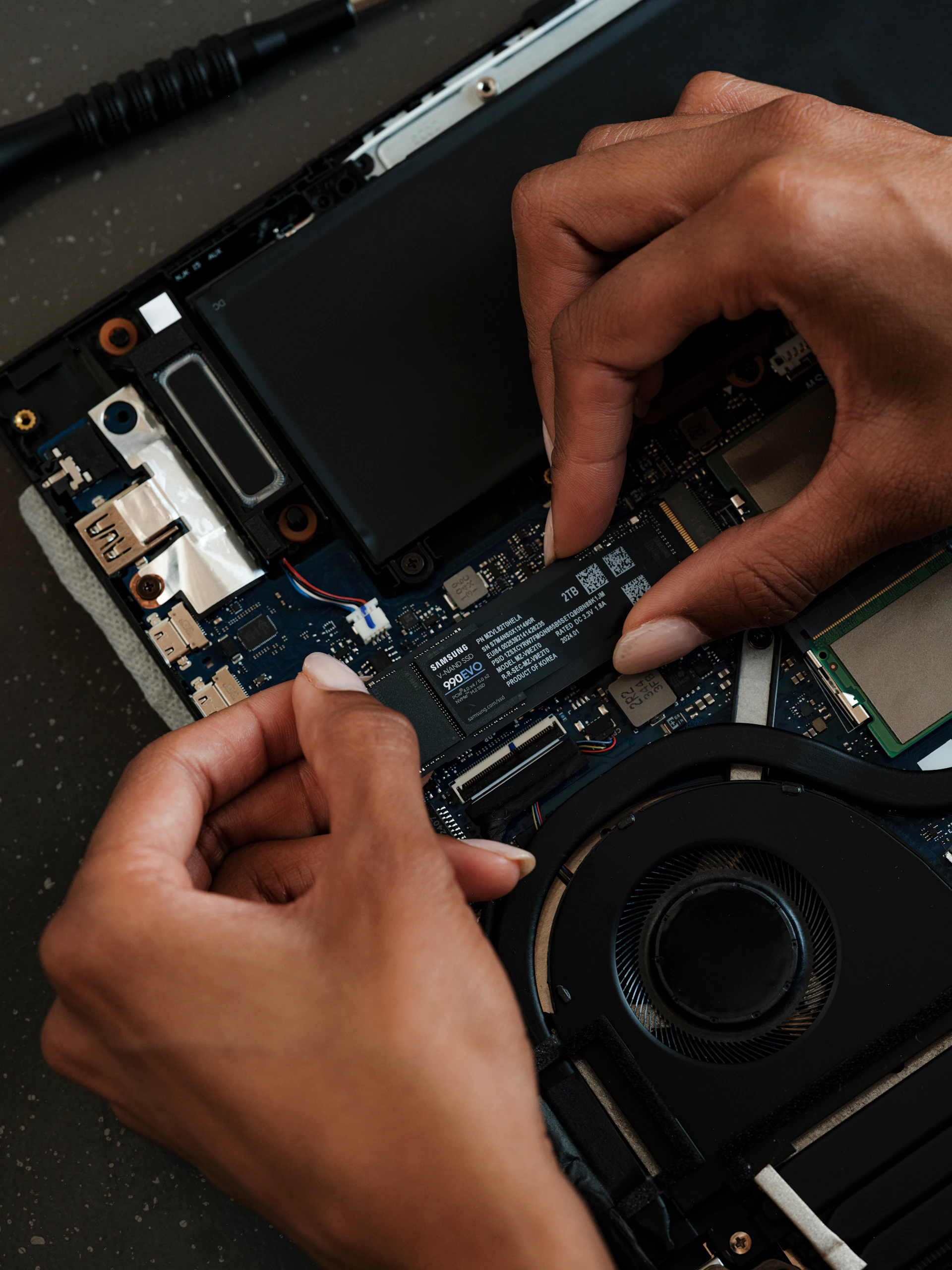 A person is removing the motherboard of a laptop