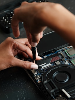 A person working on a laptop with a pen