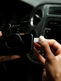 A person holding a camera in a car