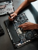 A person working on a laptop with a screwdriver