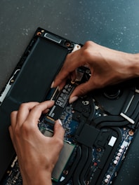 A person working on a laptop with a screwdriver