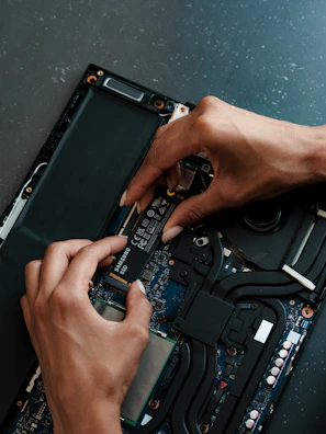 A person working on a laptop with a screwdriver