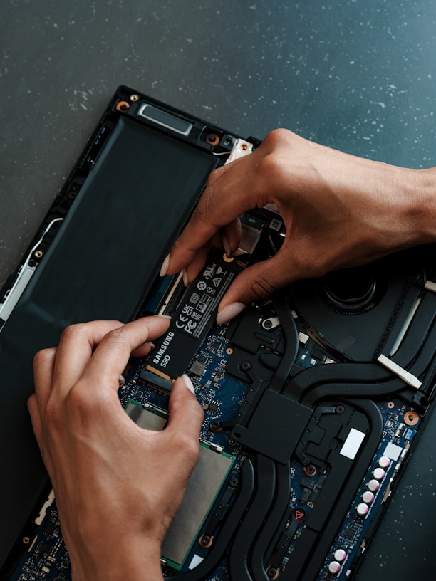 A person working on a laptop with a screwdriver