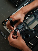 A person working on a laptop with a screwdriver