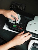 A person using a video game controller on a table