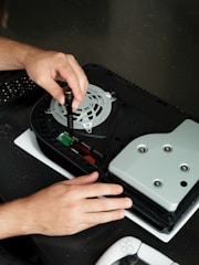 A person is working on a games console