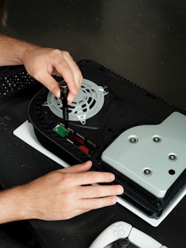 A person is working on a games console