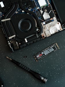 A hard drive being removed from the motherboard of a laptop