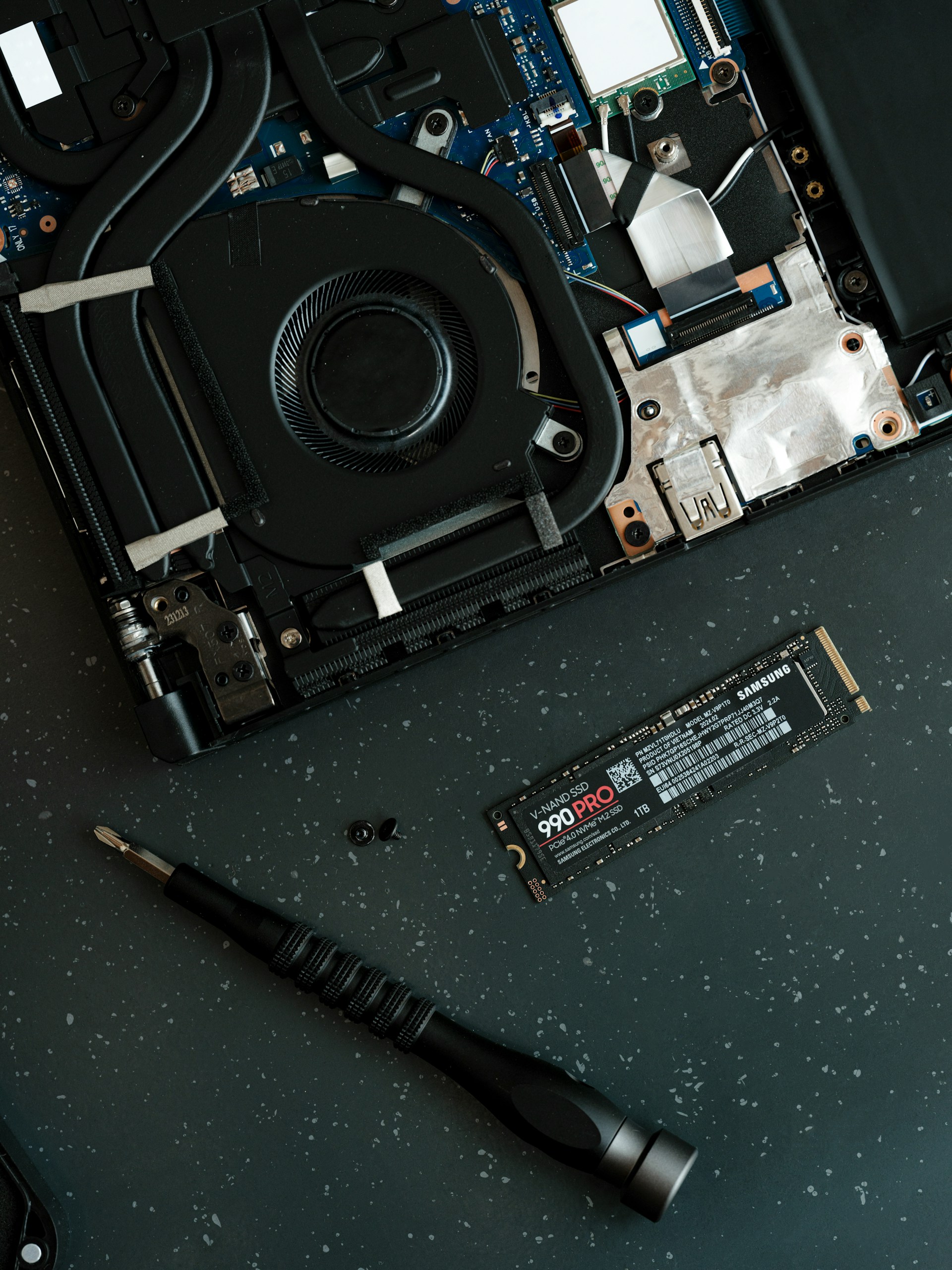 A hard drive being removed from the motherboard of a laptop
