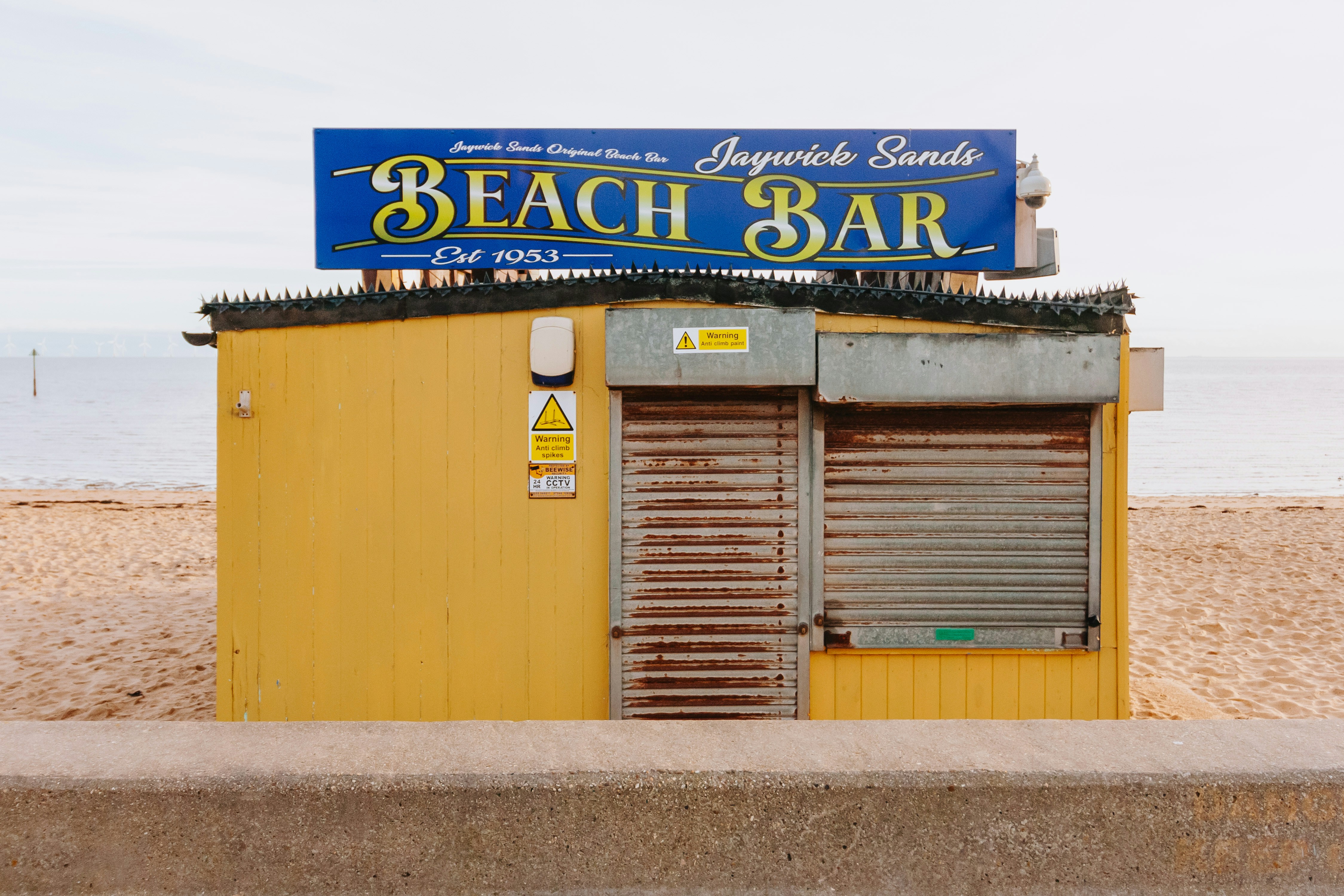 A yellow building with a blue sign on top of it