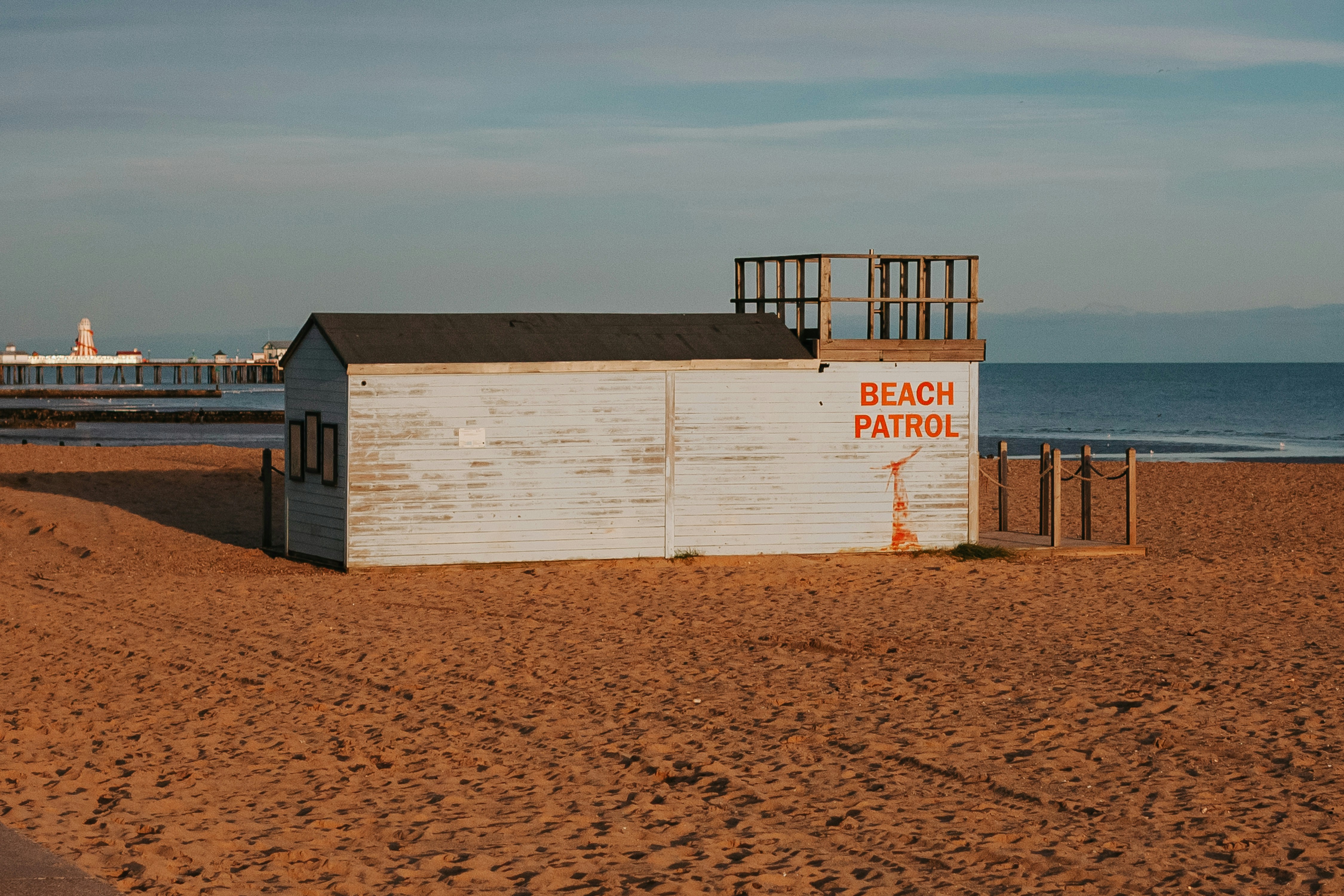 A beach hut sitting on top of a sandy beach, 