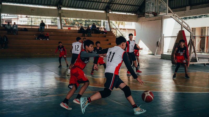 Basketball players competing on an indoor court with spectators