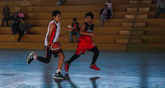 A couple of young men playing a game of basketball
