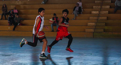 A couple of young men playing a game of basketball