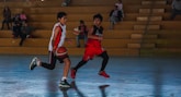 A couple of young men playing a game of basketball