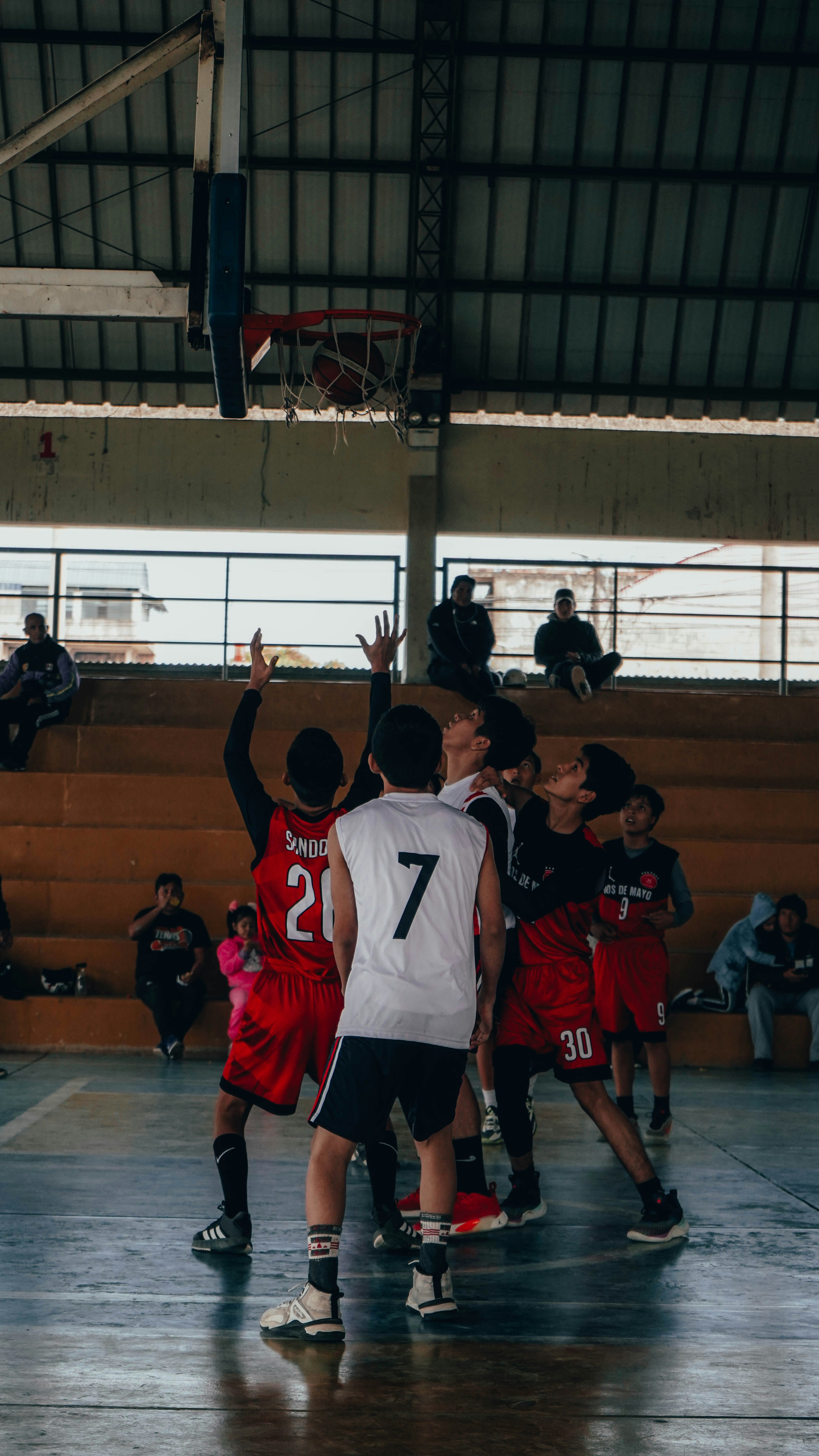 A group of young men playing a game of basketball