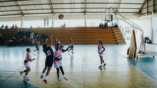 A group of young women playing a game of basketball