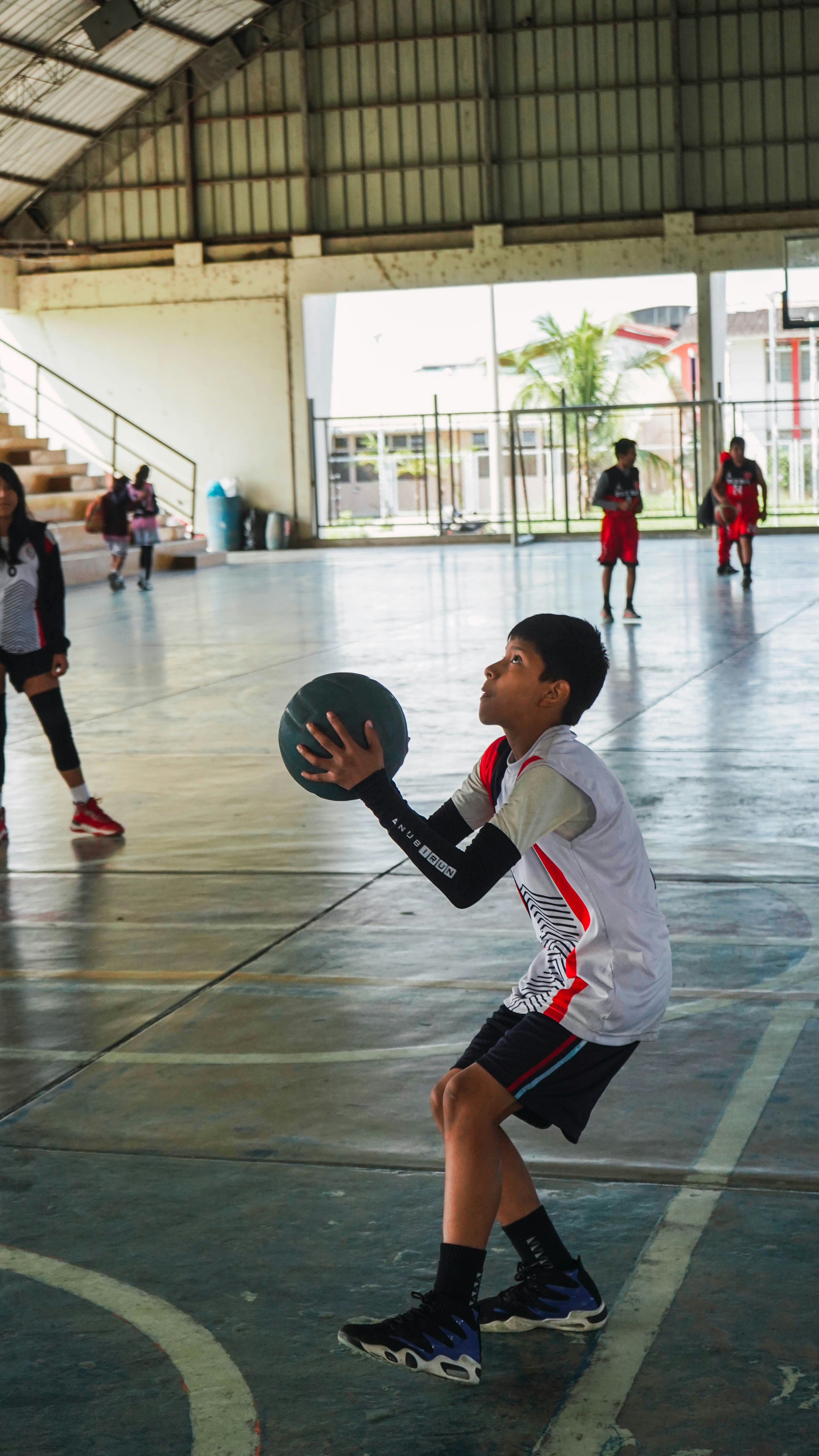 A group of young people playing a game of basketball