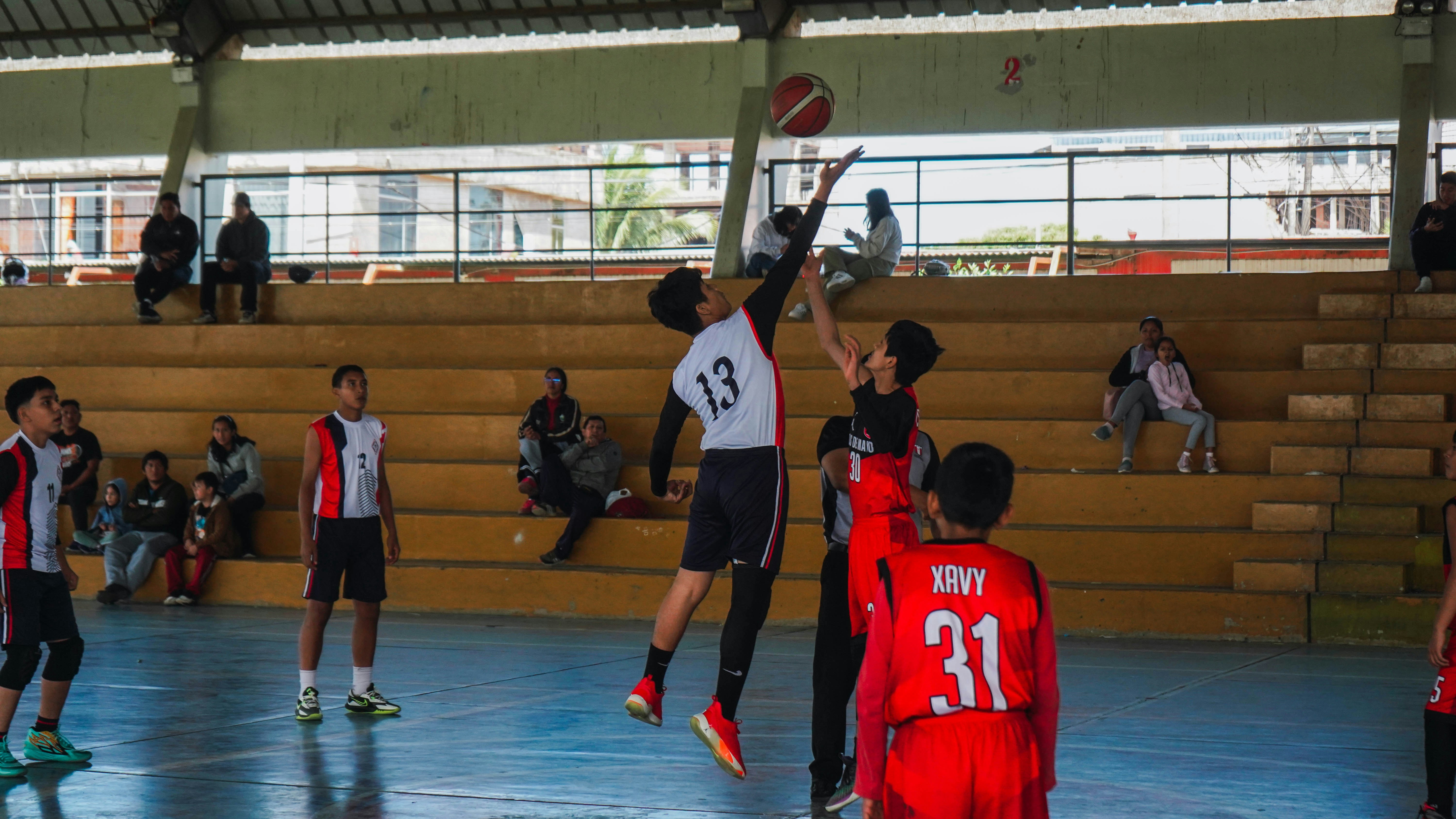 A group of young men playing a game of basketball