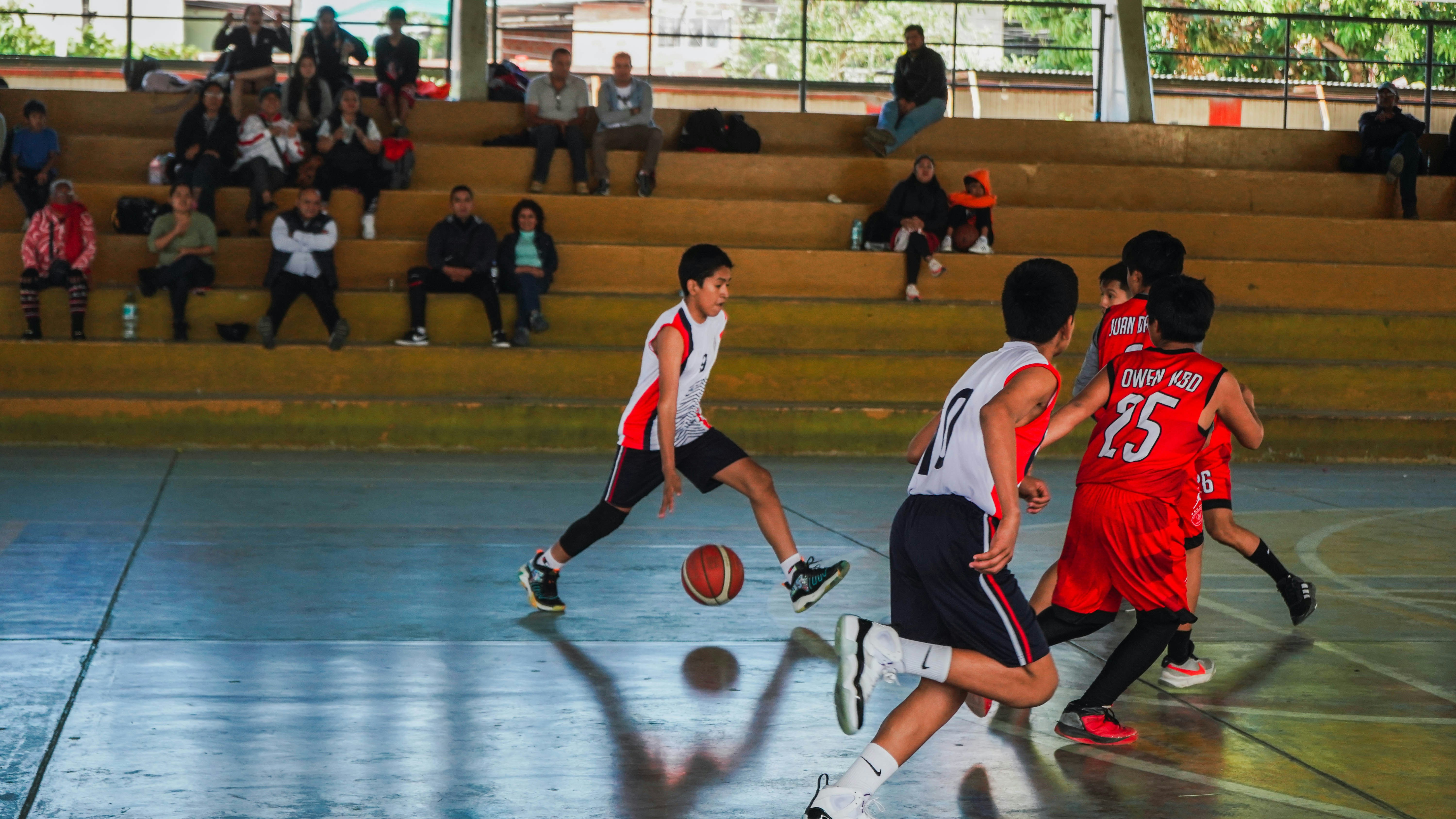 A group of young men playing a game of basketball