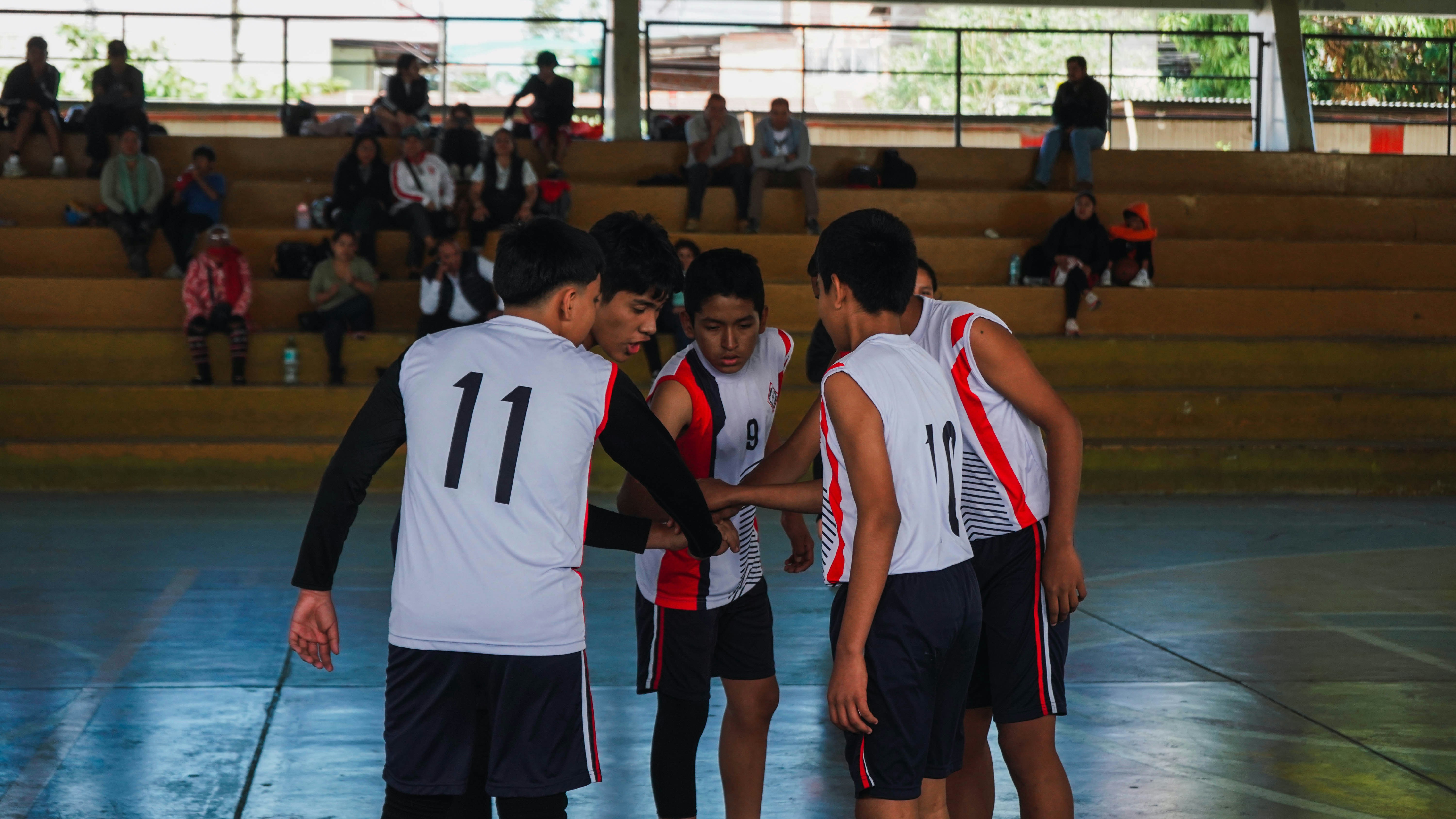 A group of young men standing on top of a basketball court