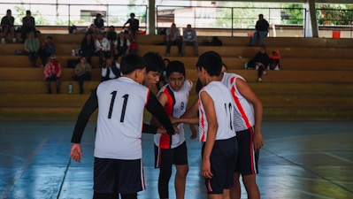 A group of young men standing on top of a basketball court