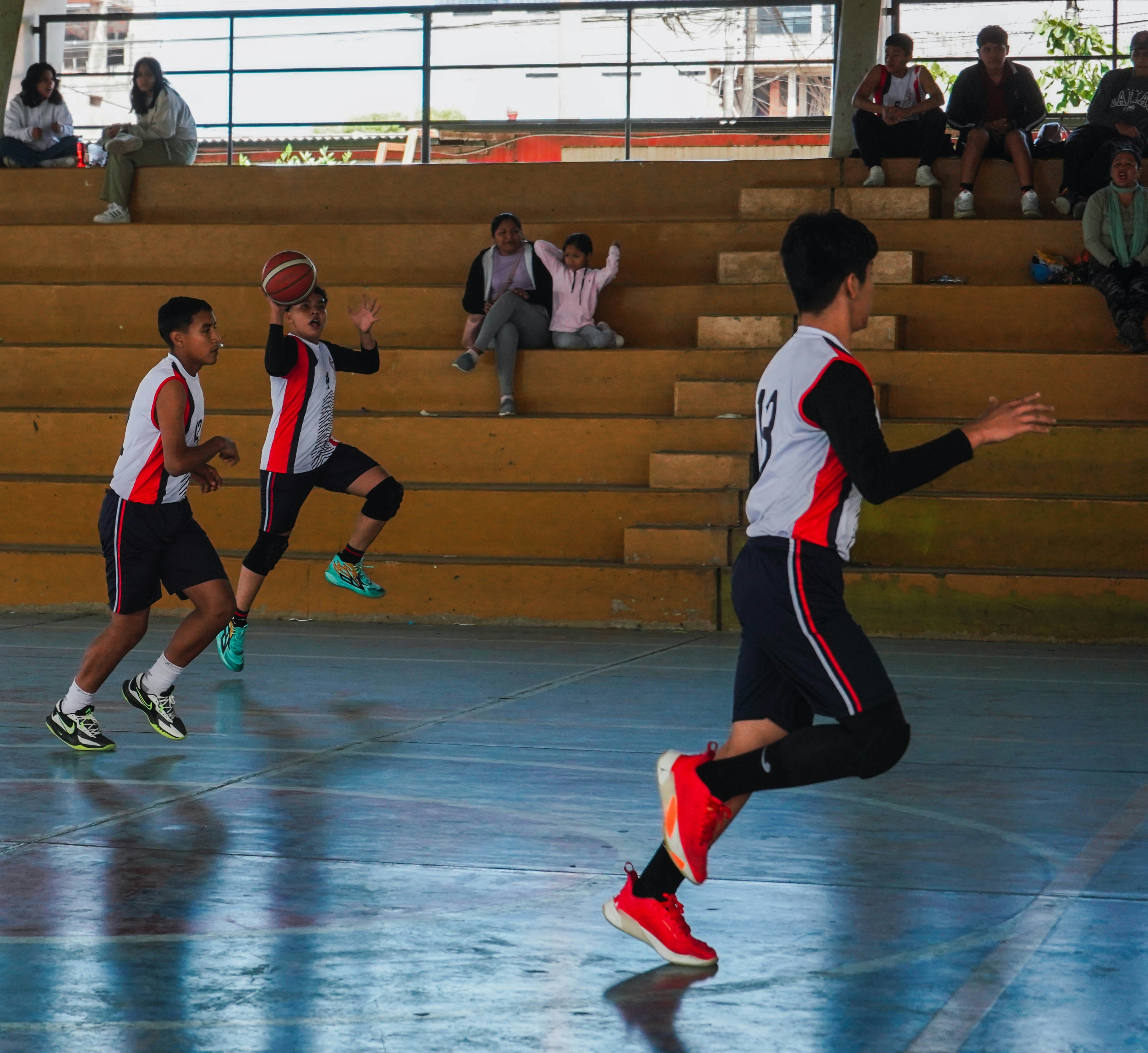 A group of young men playing a game of basketball
