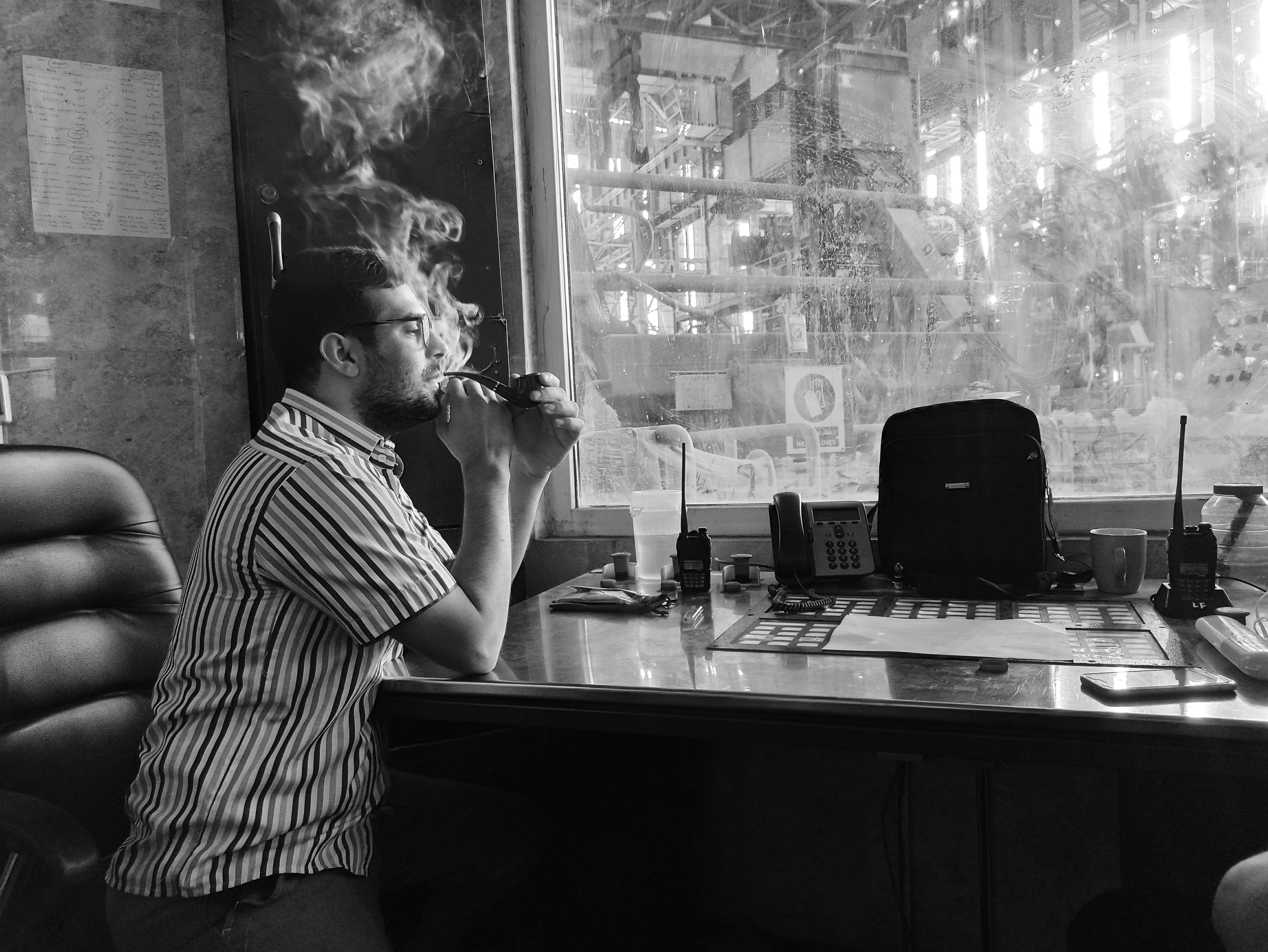A man sitting at a desk smoking a cigarette