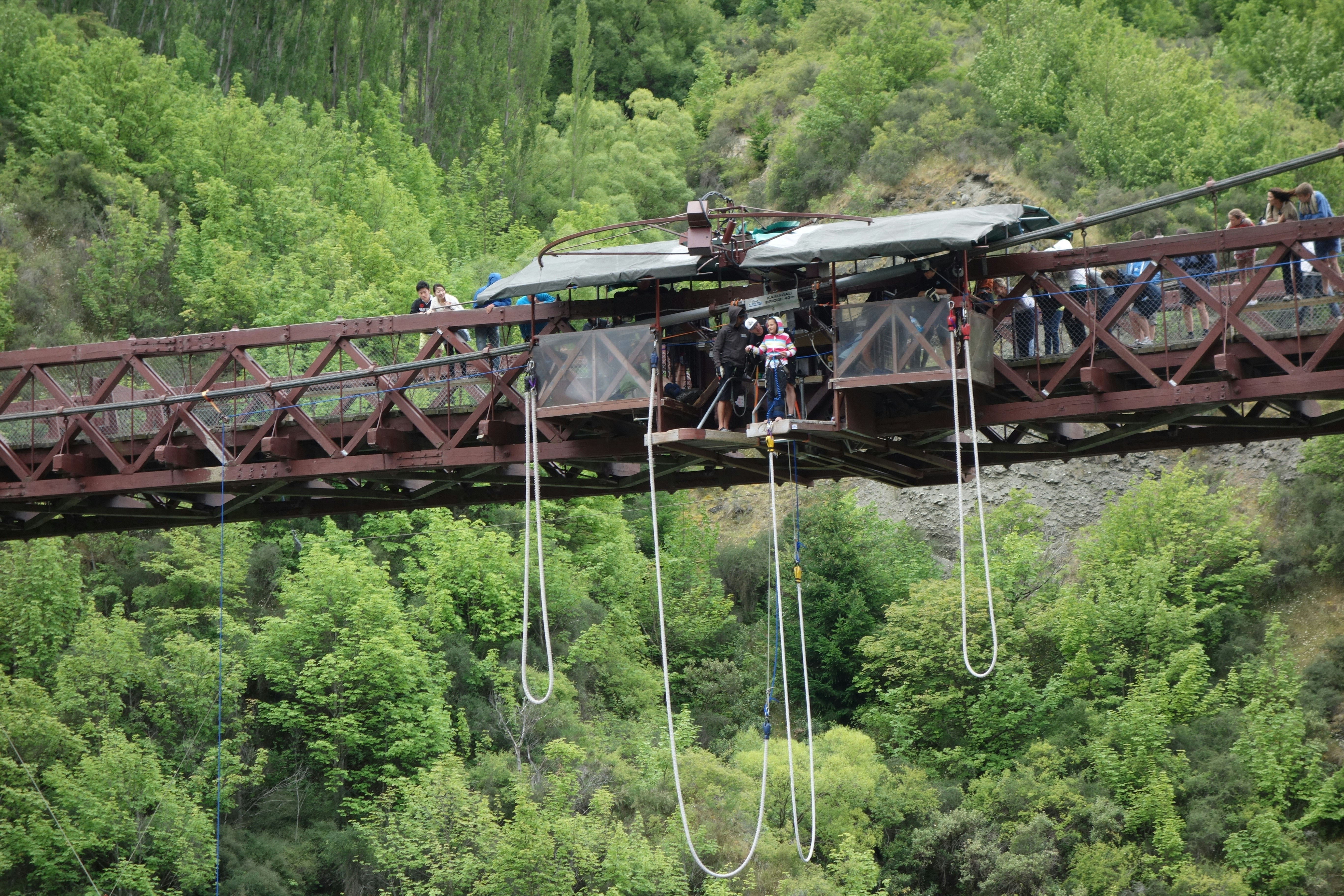 A group of people standing on a bridge over a river