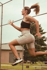 A woman is jumping in the air on a tennis court