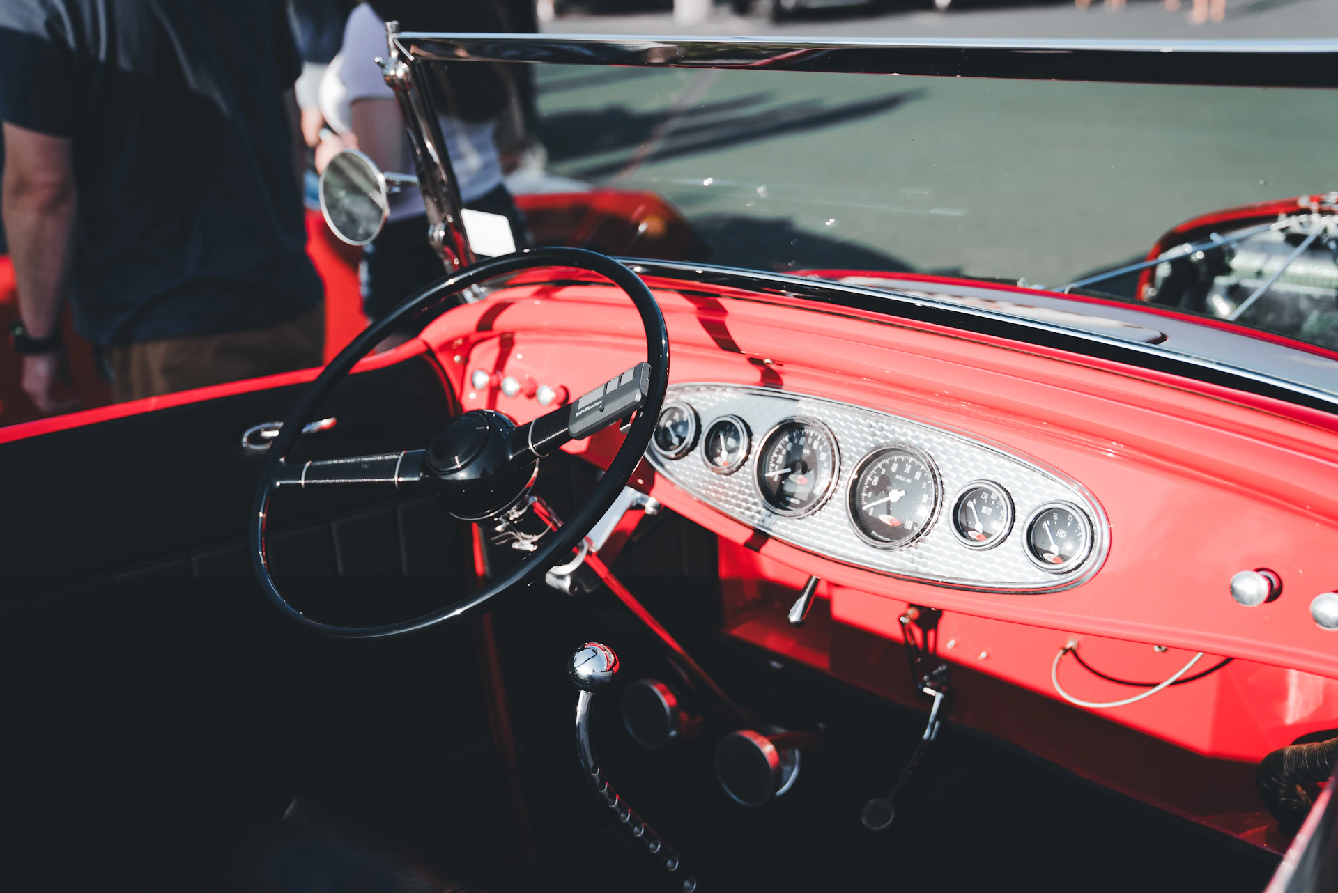 A man standing next to a red car