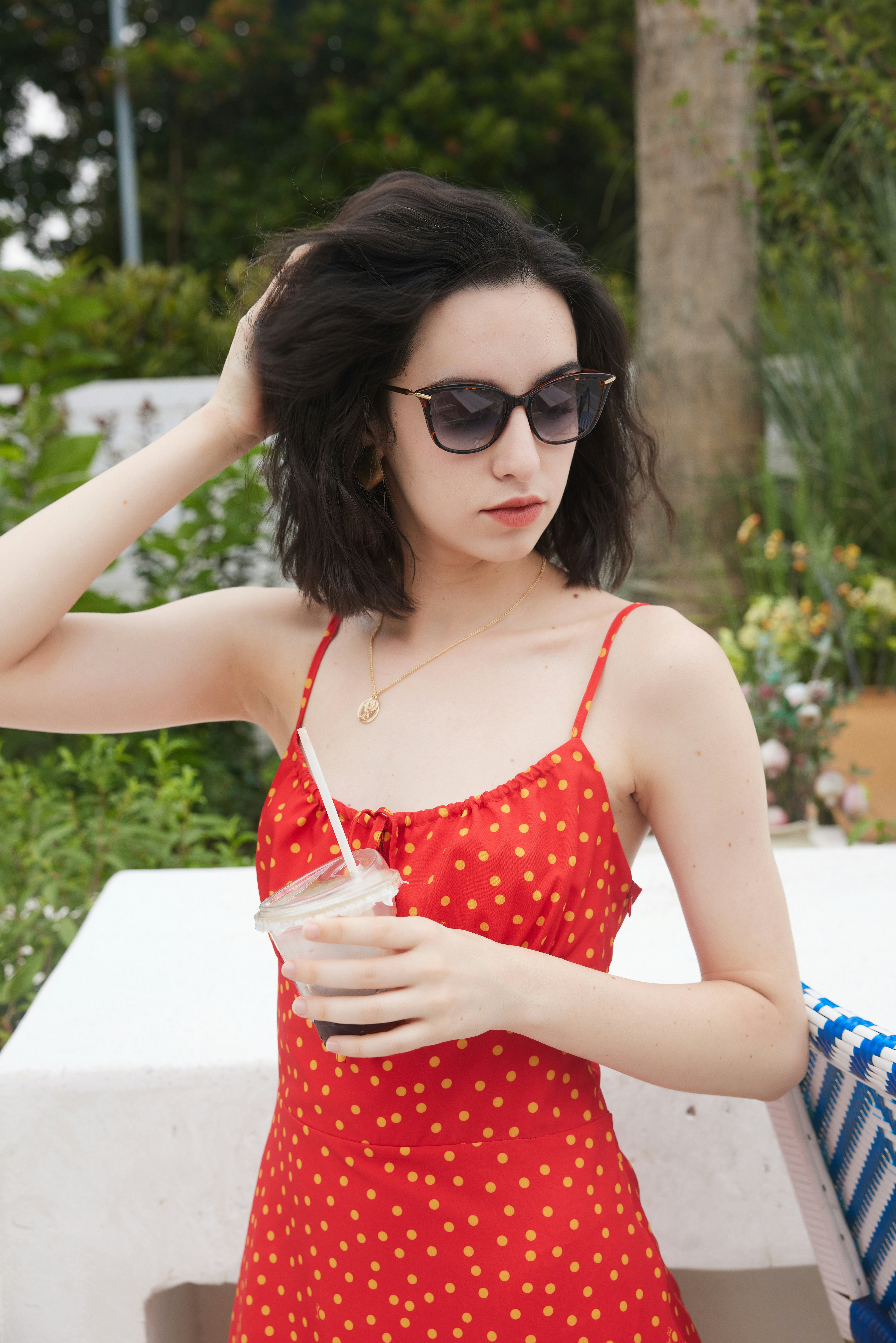 A woman in a red dress holding a drink