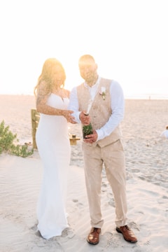 A bride and groom standing on the beach