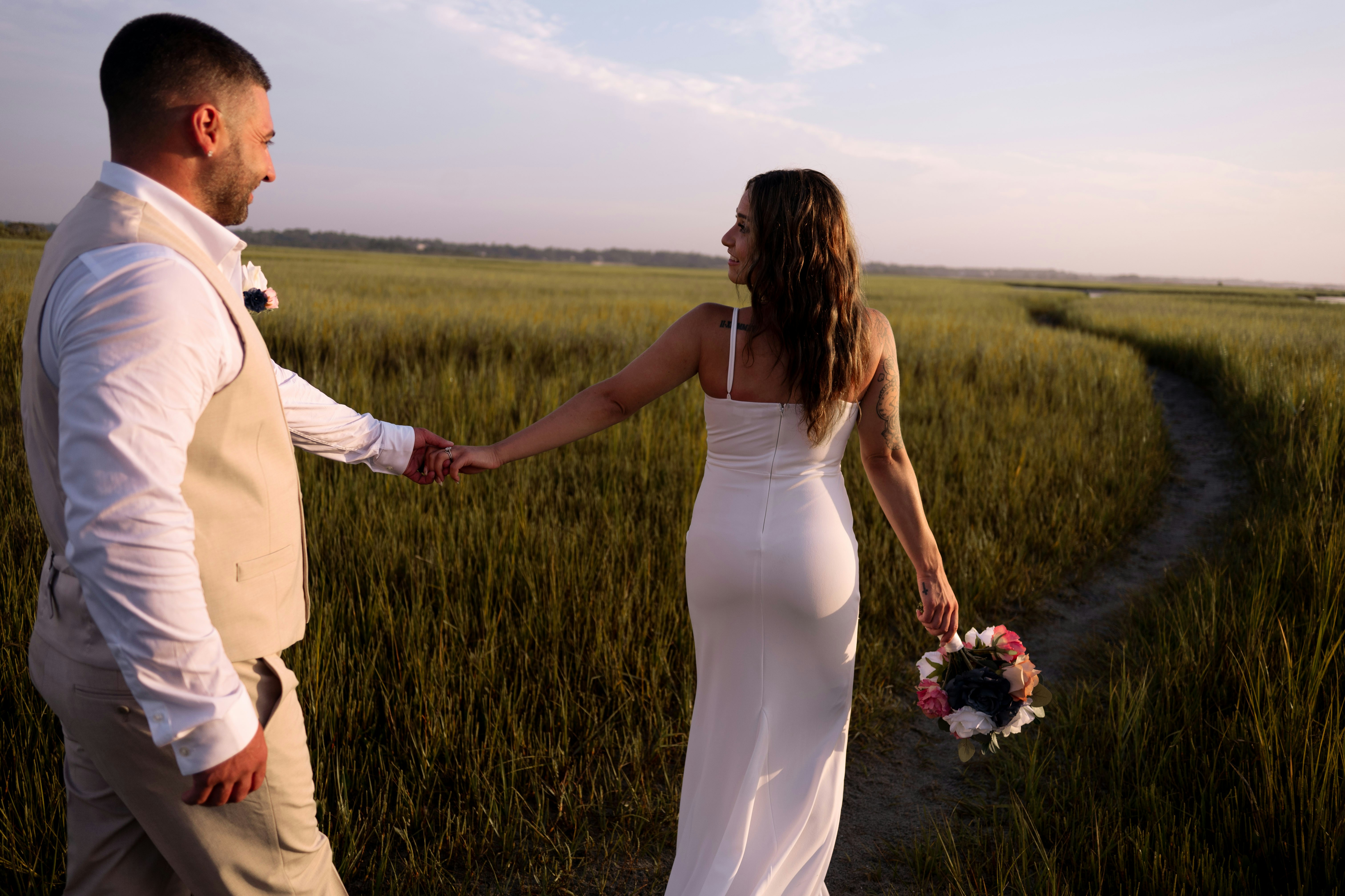 A man and a woman holding hands in a field