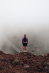 A man standing on top of a mountain in the fog
