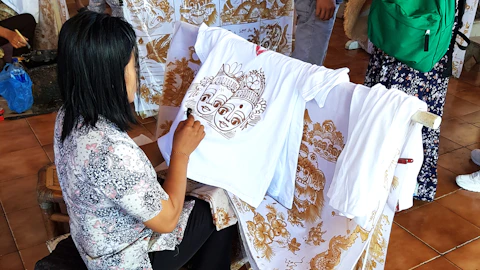 A woman sitting on a chair working on a shirt