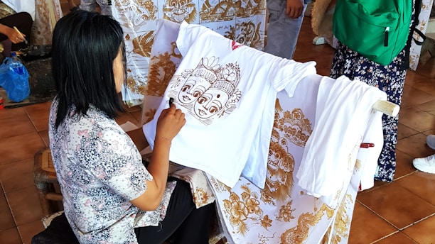 A woman sitting on a chair working on a shirt