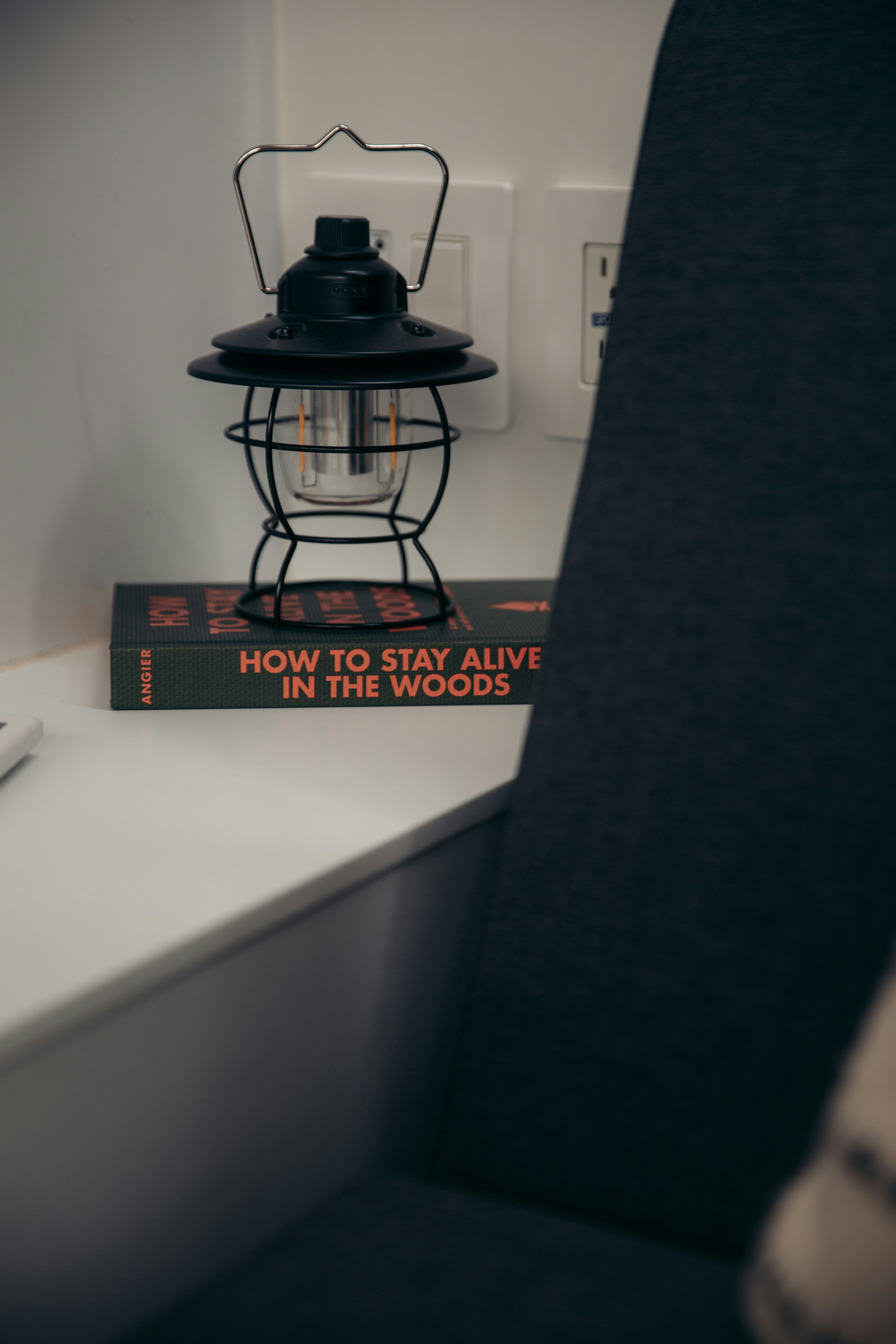 Ein Buch, das auf einem Tisch neben einer Lampe liegt