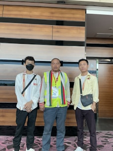 A group of three men standing next to each other
