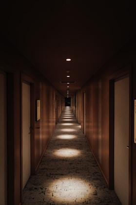 A long hallway with light coming through the doors