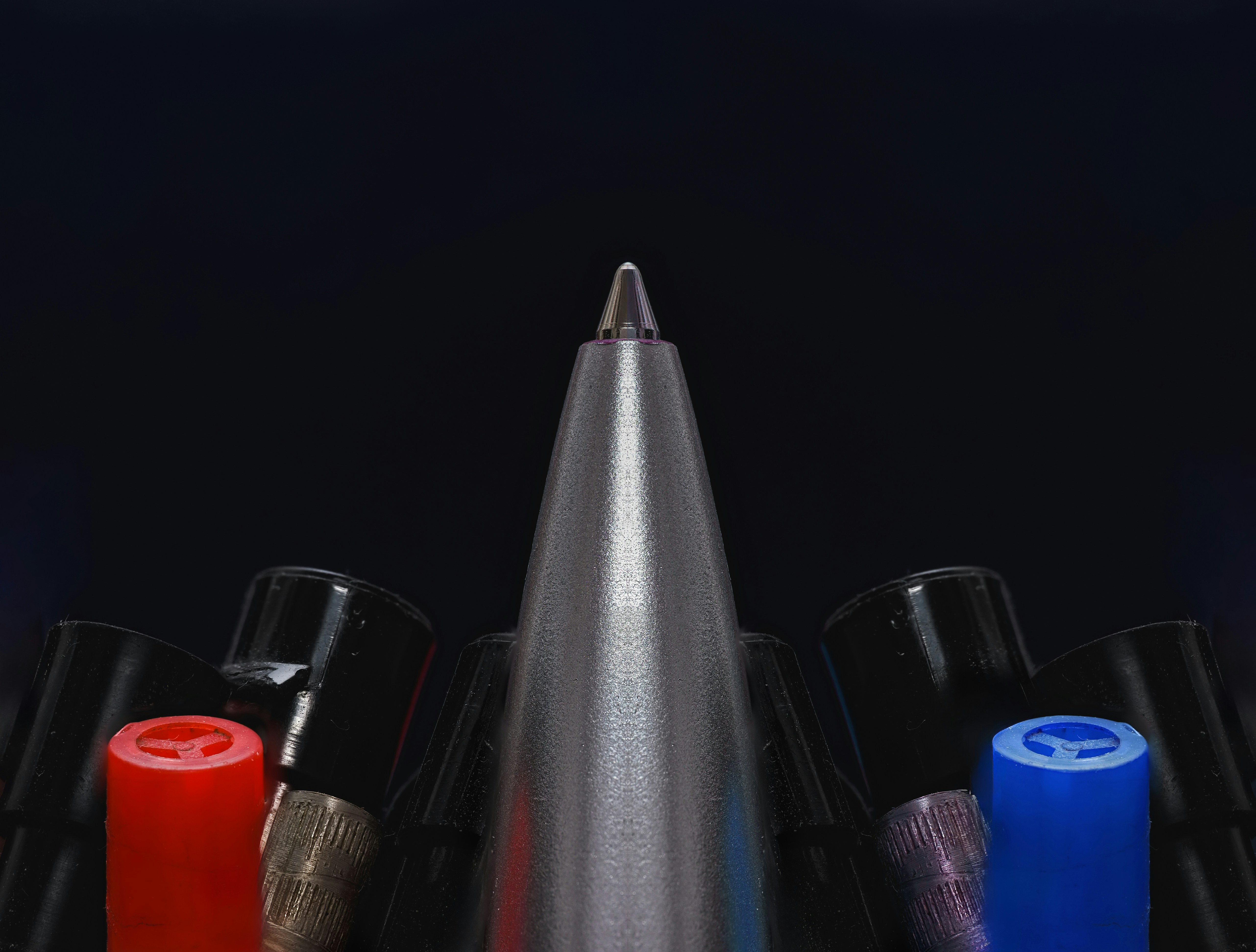 A group of different colored pens sitting next to each other