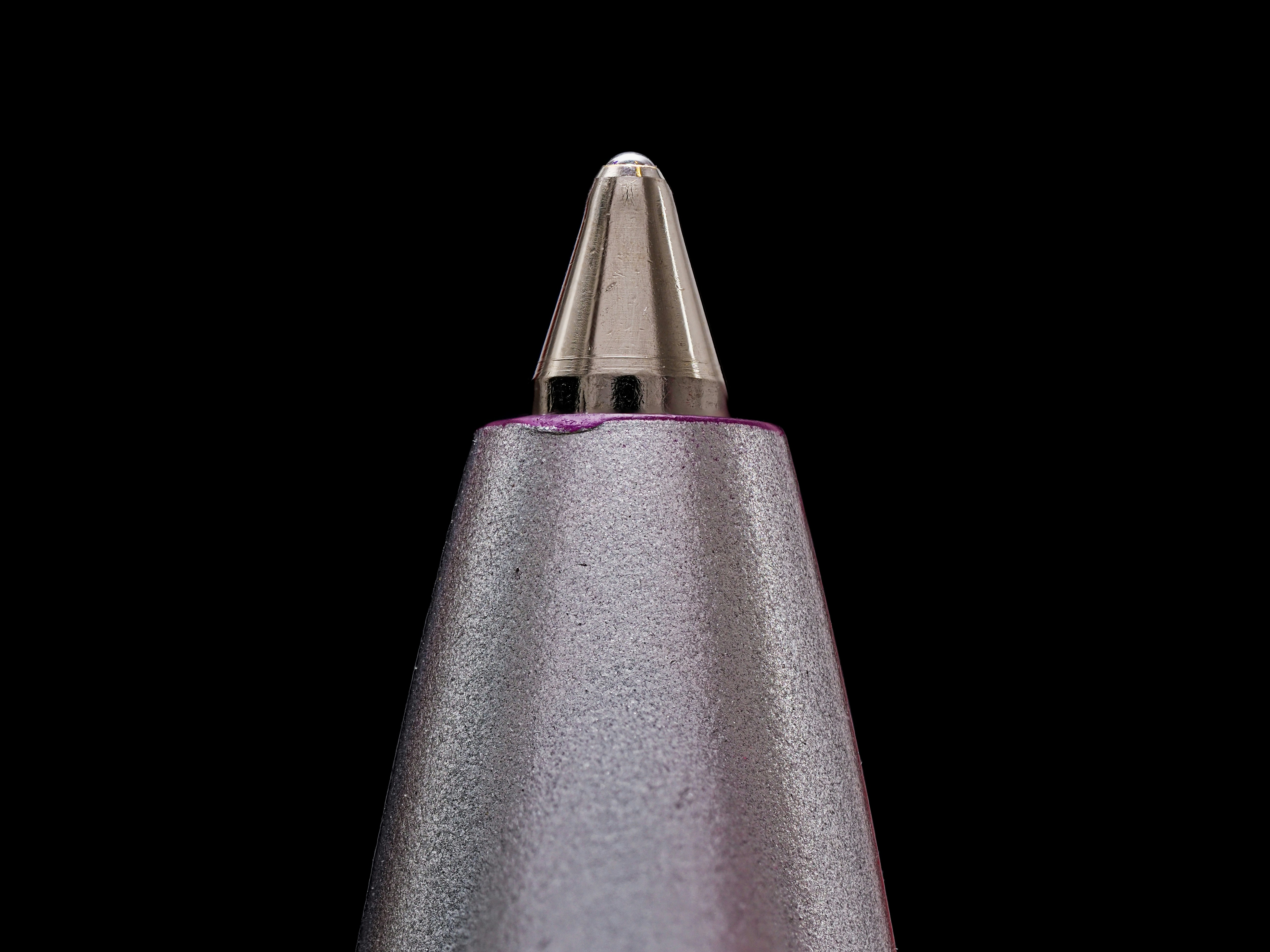 A close up of a metal object on a black background
