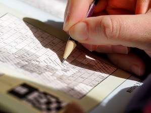 A person writing on a piece of paper with a pencil